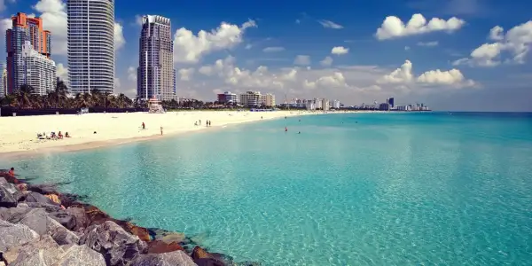 Traumhafter Strand in Miami mit türkisfarbenem Wasser und Wolken am Himmel. Perfekt für Ihre Miami Reisetipps!